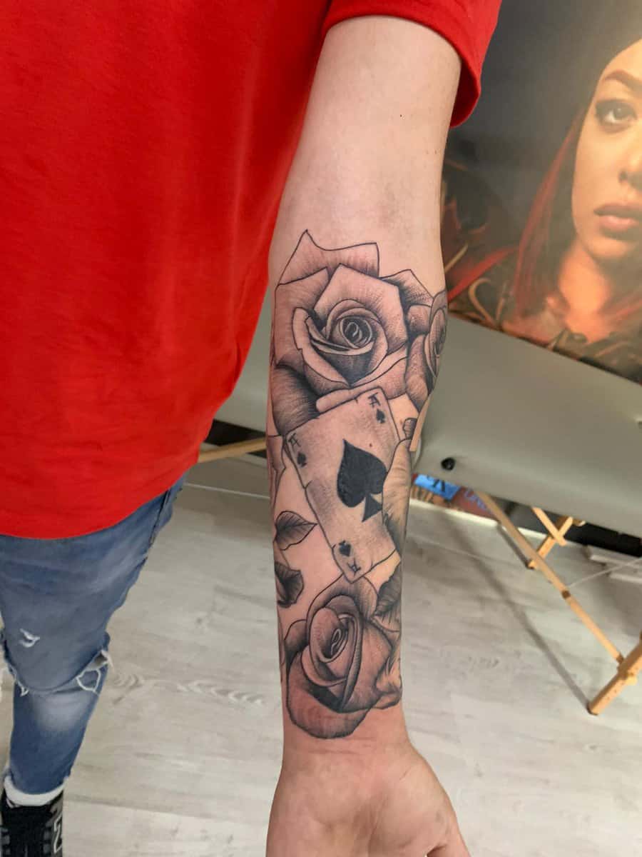 Detaliu al unui tatuaj cu trandafiri și cărți de joc
