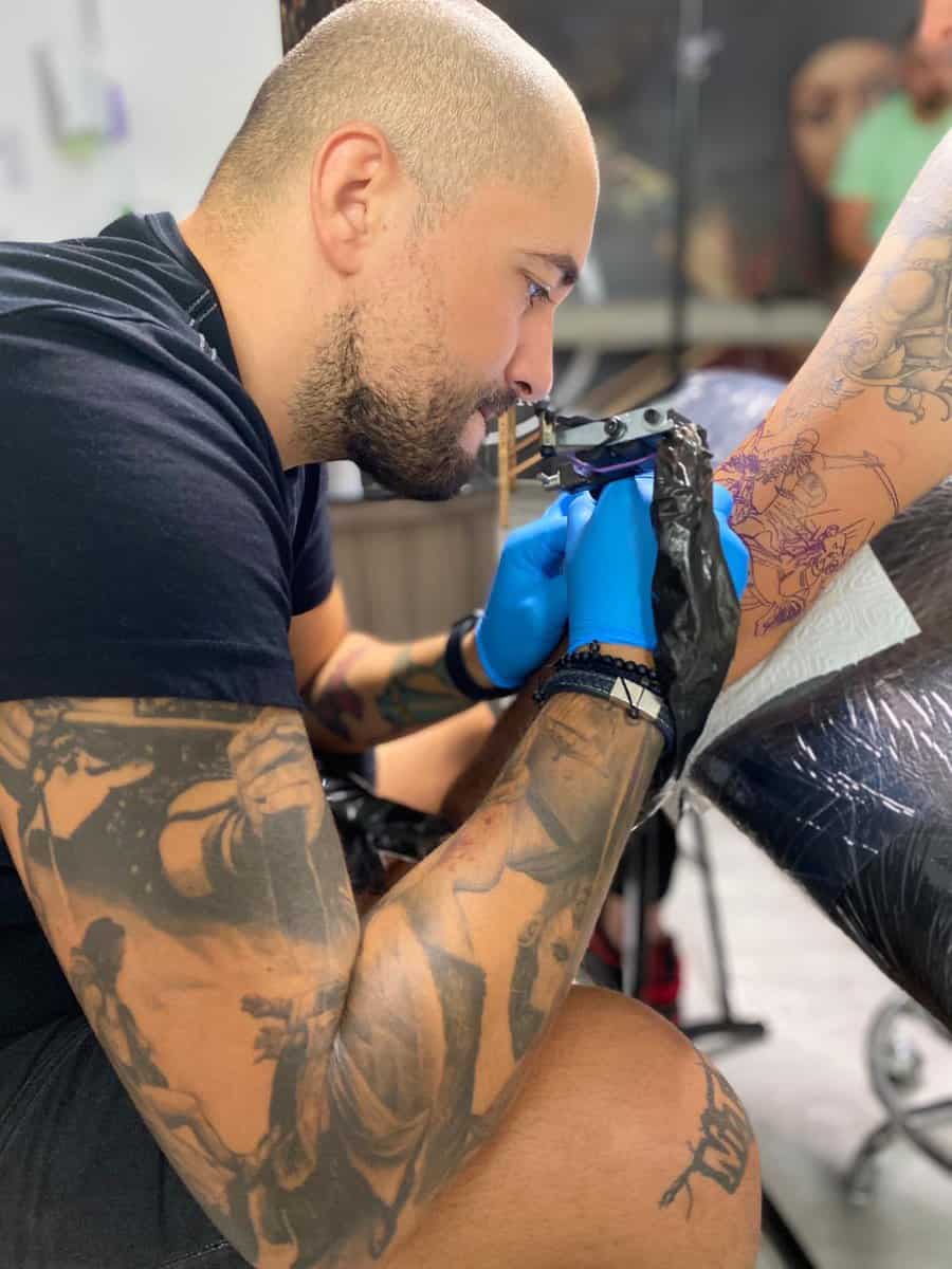 Cristi Nitu lucrând cu atenție la un tatuaj în studioul RED TATTOO