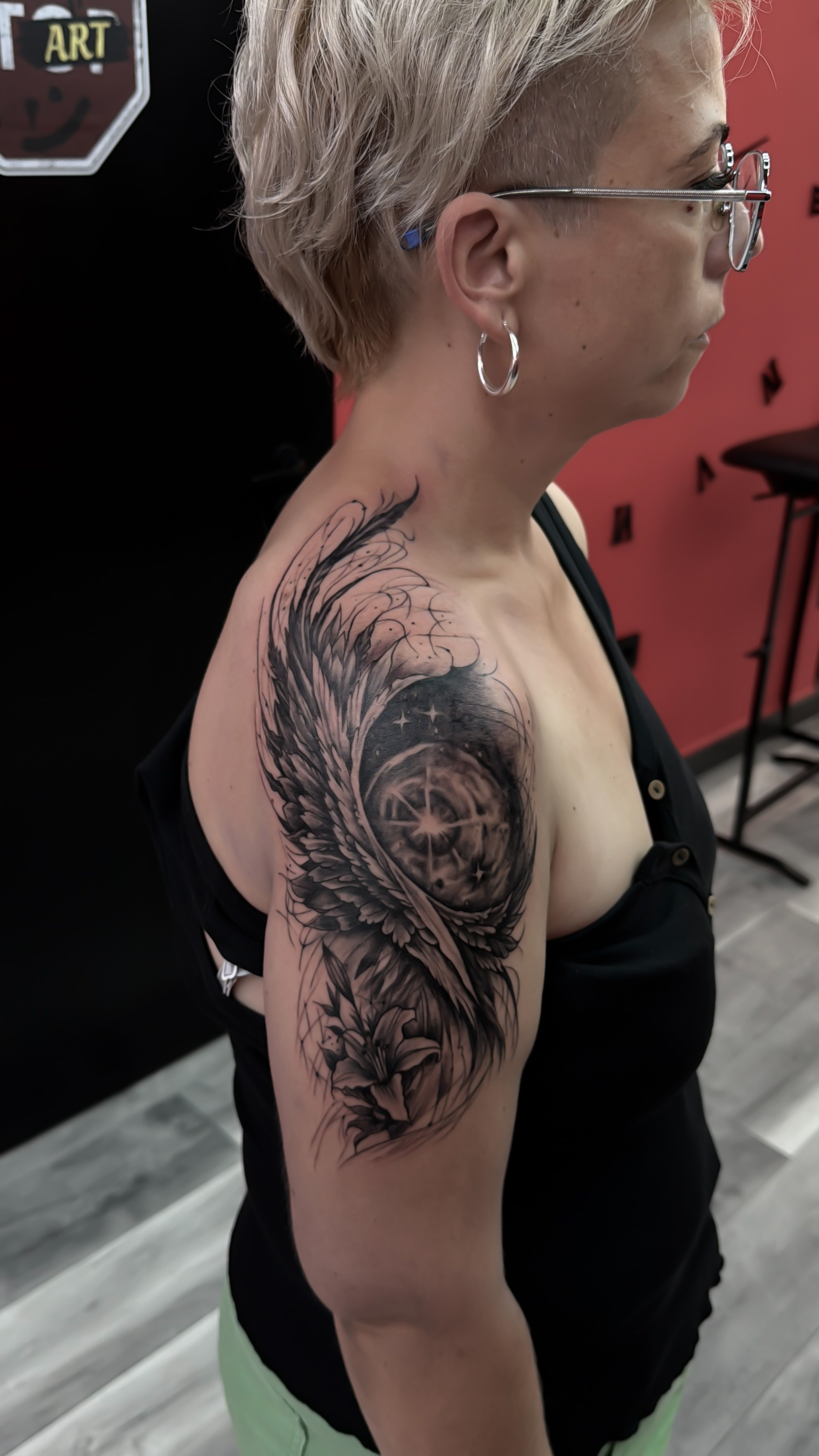 Tatuaj personalizat pe umăr cu aripi și motiv circular